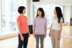 50代の女性がダンススタジオで笑顔で会話している様子